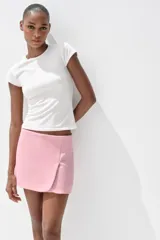 Falda pantalón corta color rosado, de tiro medio con abertura en el delantero y cierre lateral con cremallera.