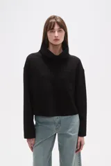 Buzo negro de manga larga con cuello alto tipo chimenea y un bolsillo cuadrado en el pecho.