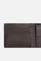 Billetera tipo cartera fabricada en piel color marrón oscuro. Cuenta con un compartimento para billetes, tres compartimentos para tarjetas, dos ranuras laterales y un monedero con cierre mediante clip.