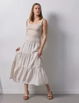 Falda midi a rayas verticales celestes y blancas, con pretina ancha elastizada en punto smock y volados en los cortes.