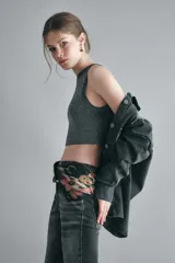 Top tejido en hilo con lurex color gris, con escote halter y sisa baja.