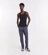 Pantalón de vestir marrón, de corte skinny, con bolsillos laterales y traseros. Se ajusta a la cintura con cinturón de cuero marrón.