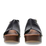 Sandalia de mujer con capellada de cuero negro, diseño cerrado en la punta (peep-toe) y pulsera ajustable con hebilla dorada en el tobillo. Posee una plataforma y taco alto de madera oscura, con detalles de tachas metálicas doradas en la unión entre la capellada y la plataforma.