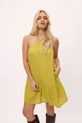 Vestido corto color verde oliva, con escote halter, corte suelto y falda con volados.