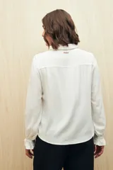 Camisa celeste de manga larga confeccionada en viscosa ligera, con detalles calados en la parte superior y pequeños volados.