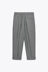 Pantalón color verde claro de tiro alto, con bolsillos delanteros, cintura elástica en la parte trasera y cierre frontal con cremallera y botones.