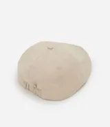 Boina color beige confeccionada en sarga de algodón, con botón en la parte superior y cierre de elástico.