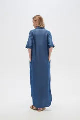 Vestido largo camisero de lyocell azul denim, corte holgado, con cuello camisero, mangas cortas con dobladillo y cierre frontal con botones.