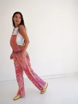 Jardineros de cuero con estampado artístico en tonos fucsia, naranja y rosa.