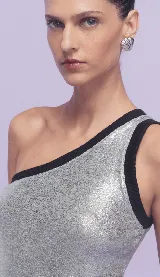 Blusa plateada de un hombro con ribete negro.