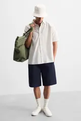 Zapatillas de cuero blanco con cordones y suela plana.