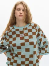 Remera tejida con diseño a cuadros color celeste y marrón, de corte ancho y manga corta caída.