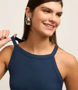 Blusa sin mangas color marrón, confeccionada en tejido rib con textura. Presenta cuello halter que resalta los hombros.