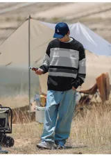 Sweater de punto con rayas horizontales en blanco, gris y negro.