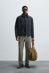 Pantalón chino de vestir negro, corte slim fit, con bolsillos laterales y traseros. Cierre frontal con cremallera y botón.