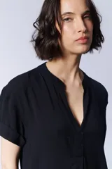Vestido corto camisero negro con cuello en V y mangas cortas.