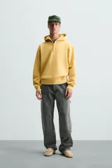 Pantalón gris de corte relaxed fit, con cinco bolsillos, efecto lavado, aplicación de tira y bolsillo multifunción en perneras. Cierre frontal con cremallera y botón.