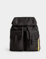 Mochila de tela color lila, con solapa con broche y tira de ajuste, doble bolsillo frontal con broche y pouch con charm lateral en forma de cartera.