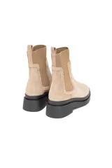 Bota Chelsea de gamuza color beige con elásticos laterales al tono y suela track negra.