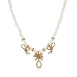 Collar de perlas con dijes de lazo dorados con incrustaciones de strass y dije central con forma de lágrima.