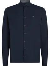 Camisa de vestir azul marino de algodón regenerativo, con cuello inglés, manga larga y logo bordado en el pecho.