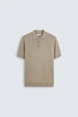 Polo de manga corta color beige, de punto con mezcla de viscosa, cuello solapa y cierre frontal con tres botones.