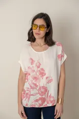 Blusa italiana de viscosa con estampado floral sobre fondo natural, cuello redondo y mangas cortas. Calce holgado, talle único.