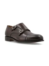 Zapato de vestir marrón oscuro para hombre, estilo monk strap con doble hebilla plateada y puntera redondeada.