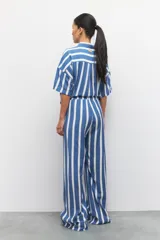 Pantalón largo azul con rayas verticales blancas, de corte amplio, con cintura elastizada y cordón ajustable.