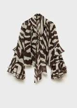 Blusa de manga larga acampanada con estampado animal print bicolor. Tiene cuello pico con lazo, detalle de volantes y diseño recto.