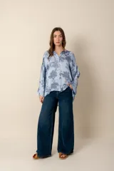 Camisa blanca con estampado de diseño bandana en tonos beige, de corte amplio, con cuello camisero y cierre frontal con botones.