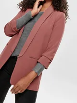 Blazer color ladrillo, de corte recto, con mangas 3/4 y solapa tipo smoking. Presenta bolsillos laterales con solapa y cierre abierto sin botones.