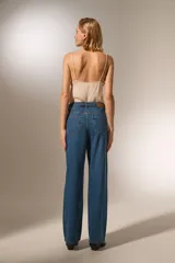 Pantalón jean azul de calce recto y tiro alto, con bolsillos y apliques de strass.