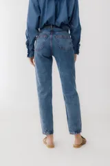 Pantalón de jean azul oscuro, corte mom, con pespuntes rojos y confeccionado en 100% algodón.
