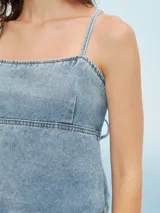 Top azul de denim con breteles finos y corte crop.