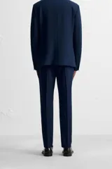 Pantalón de vestir negro slim fit, confeccionado en tejido con viscosa. Cuenta con bolsillos frontales y traseros de vivo. El cierre es frontal con cremallera y botón.