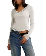 Top de manga larga color crema, de punto ligero tipo pointelle con escote en V y detalles de encaje en el cuello y puños.