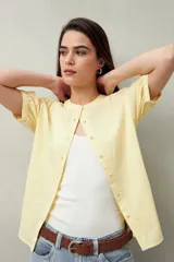 Camisa amarilla de algodón, con cuello mao, manga corta abullonada y botones forrados.