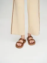 Sandalias blancas con doble tira ancha y plataforma negra.