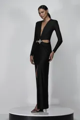 Vestido largo negro de jersey con escote en V profundo, mangas largas, espalda descubierta, abertura lateral en la falda y flecos de cristales en la cintura.