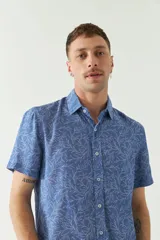 Camisa de hombre estampada, de manga corta y fit slim. Presenta cartera abotonada y logo bordado.