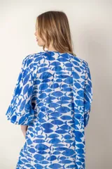 Vestido largo con estampado de peces azules sobre fondo blanco, cuello en V y mangas cortas.