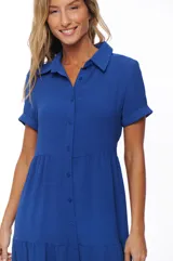 Vestido midi camisero azul con botones frontales, corte en la cintura y falda con volantes.