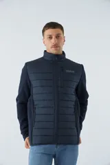 Campera azul marino con frente acolchado y mangas de felpa. Tiene cuello alto, cierre frontal, bolsillos laterales con cierre y logo de la marca en el pecho.