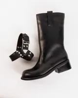 Bota de cuero marrón oscuro con caña media, estribo desmontable y hebilla metálica. Taco de madera de 5cm y suela de caucho.