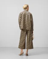 Sobrecamisa de poliuretano con estampado de piel de serpiente en tonos marrones y negros. Tiene cuello bowling, cierre con botones, manga larga con puños abotonados y forro de algodón.