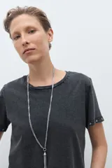 Remera de algodón color bordó, con cuello redondo, manga corta y detalle de ojalillos metálicos en el borde de las mangas.