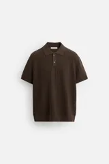 Polo marrón de punto con textura, corte regular fit, cuello solapa con cierre de dos botones, manga corta y terminaciones en rib.