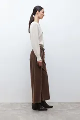 Cardigan de tejido de punto color beige melange, con escote en V, manga larga abullonada y cierre frontal con botones oscuros.