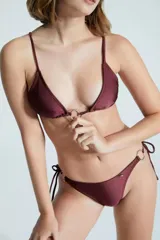 Corpiño de bikini color borgoña, con breteles finos regulables y argolla metálica en el centro del busto. Se ata en la espalda.